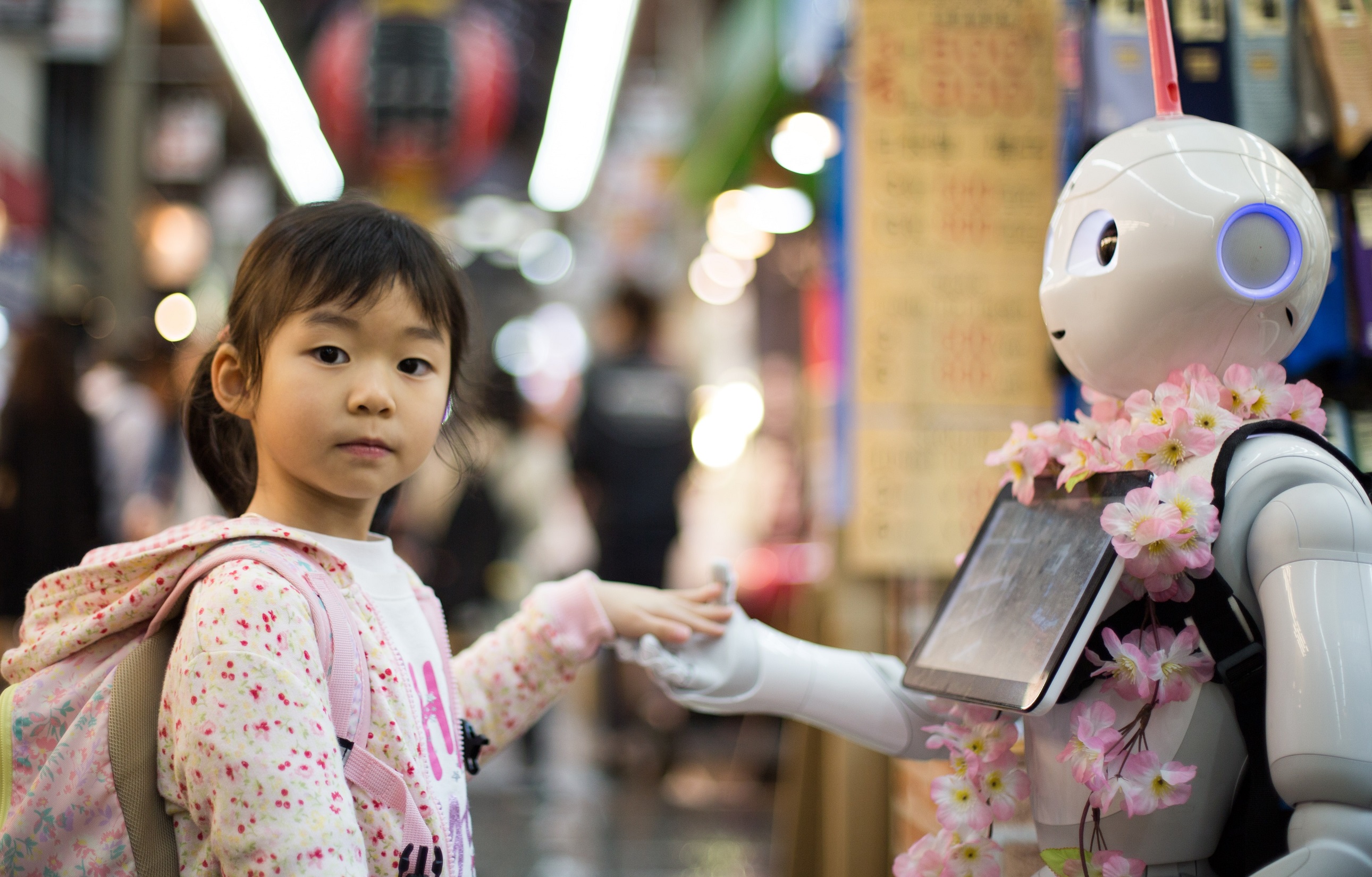 japońska dziewczynka głaszcze robota. oferta wycieczek objazdowych po Japonii dostępna w biurze podróży OdraTravel w Szczecinie
